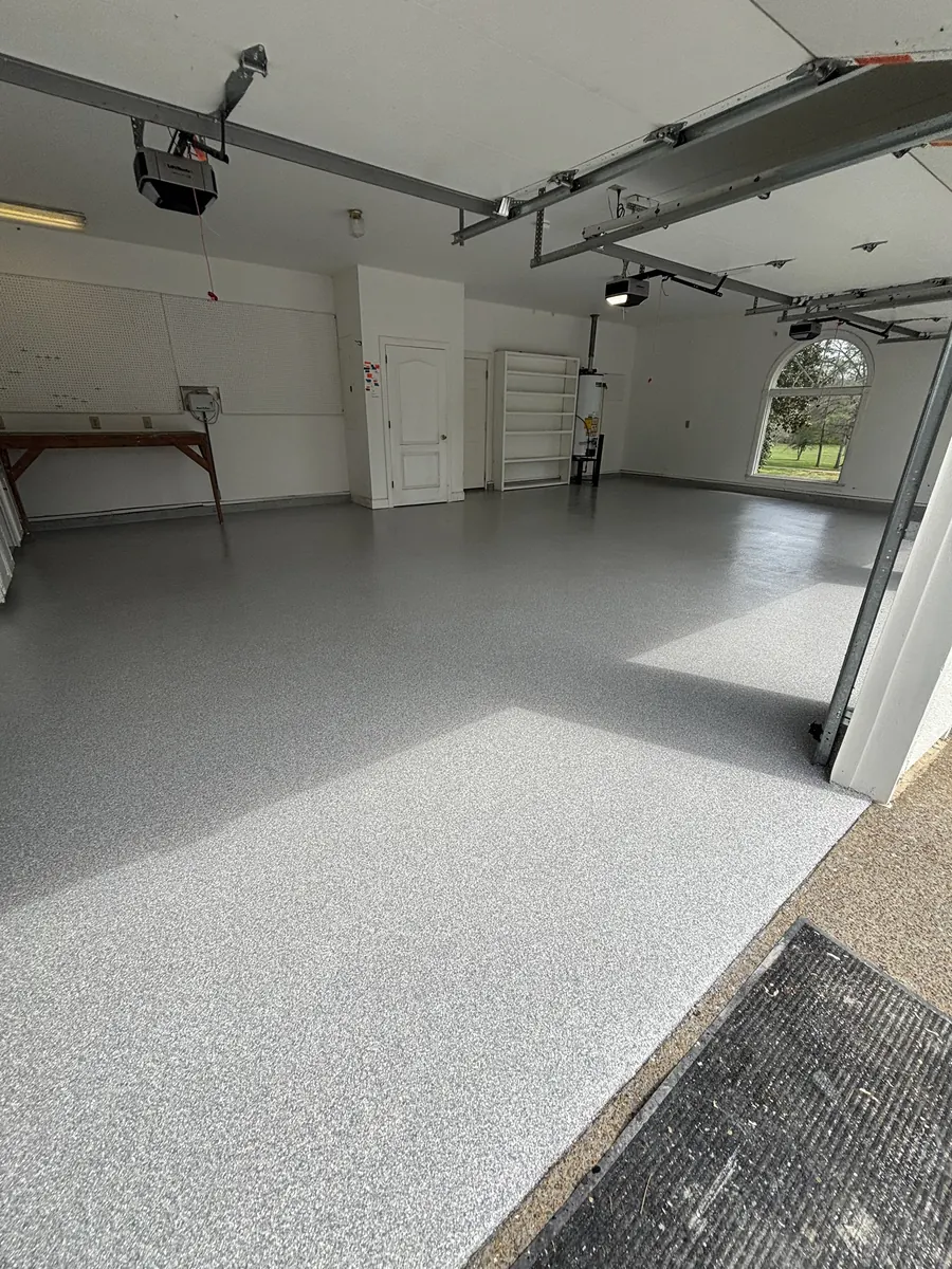 Two-car garage with a light gray Penntek flake floor installed by Three Stone