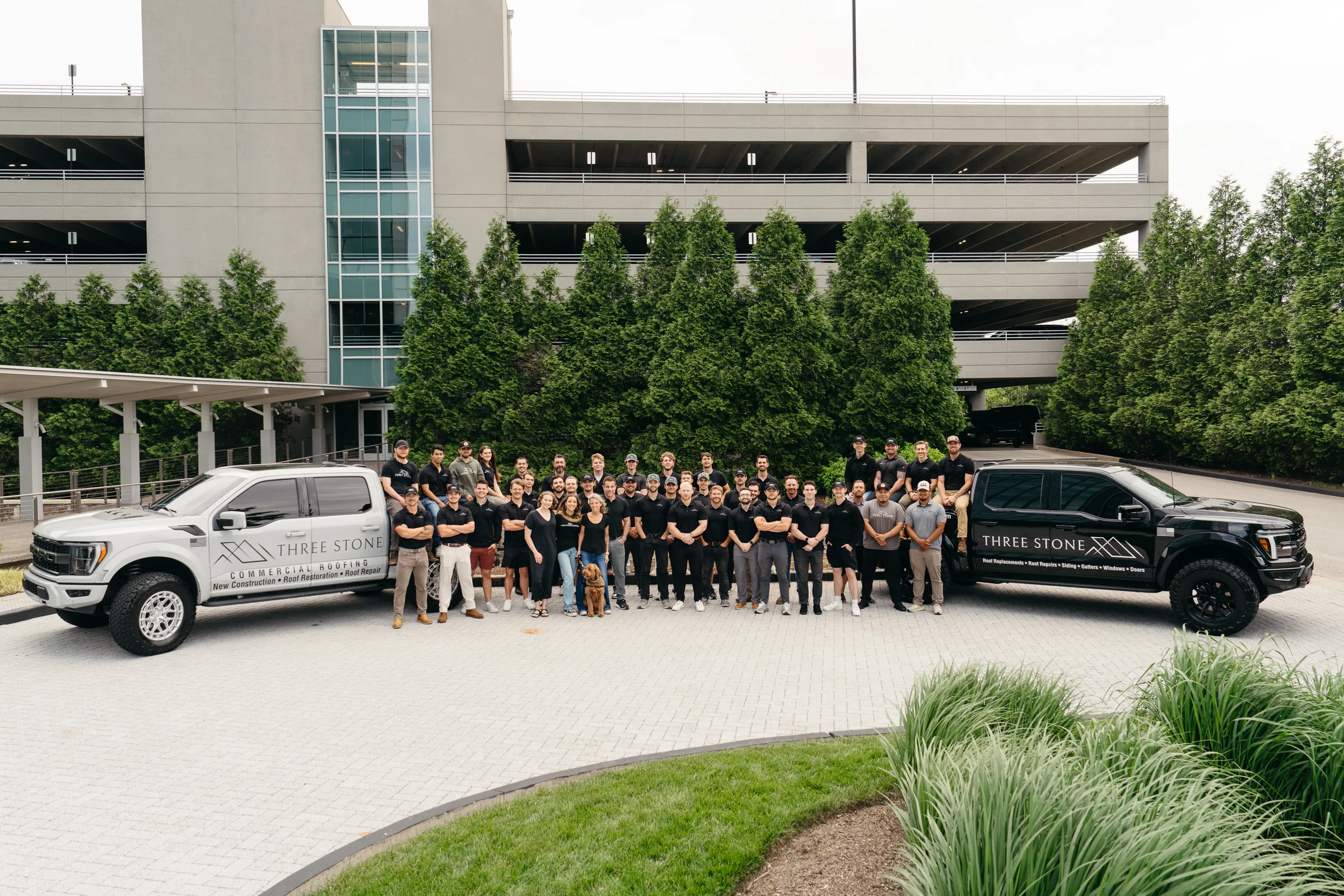 The Three Stone team in front of the company trucks