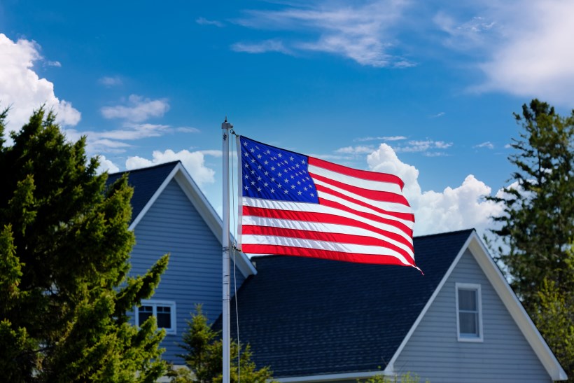Military person saluting an American flag in the background