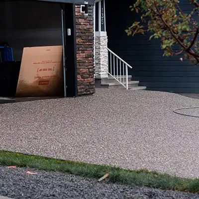 Aggregate driveway next to an open garage door