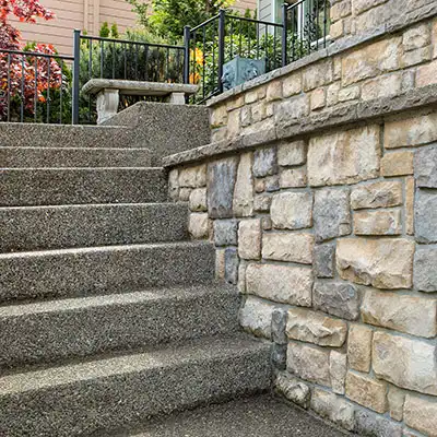 Concrete staircase next to a stone wall